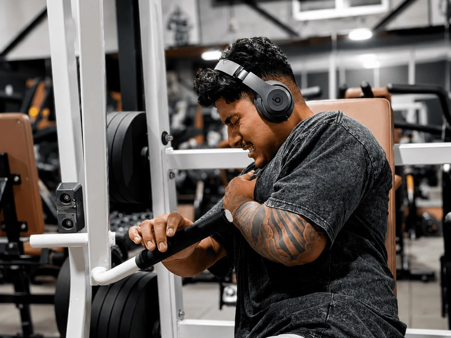 A member training on a plate-loaded machine on the Iron Shogun floor